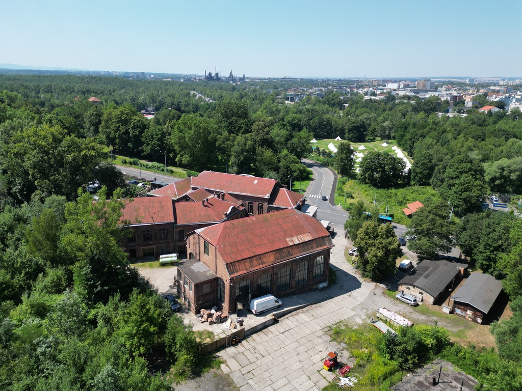 Interiér Hangáru 65 — cihlové zdivo, ocel a vysoká okna.